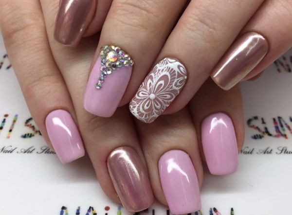 Conception d'ongles de couleur rose avec strass, étincelles, frottements, bouillons, monogrammes, motifs, inscriptions, argent