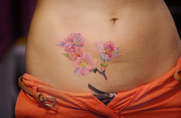 Tatuatge del ventre per a noies. Fotos, esbossos de flors, inscripcions, animals, patrons