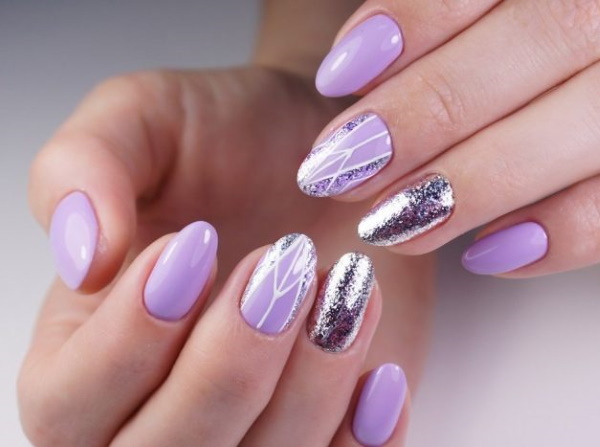 Conception des ongles lilas. Photo avec un motif, des paillettes, des strass, de l'argent, de l'or, des combinaisons avec d'autres couleurs