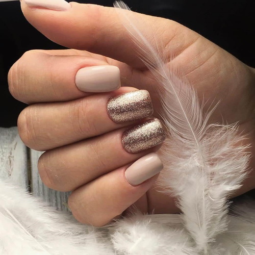 Manucure beige avec paillettes, strass sur ongles courts à la base, frottés, motif. Une photo