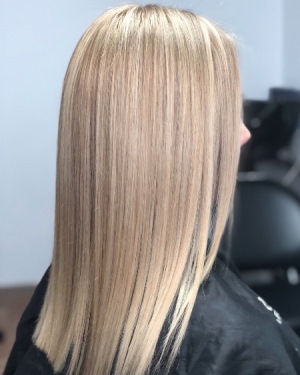 Couleur des cheveux blonds chauds. Photo aux racines foncées, teinte rose, peinture