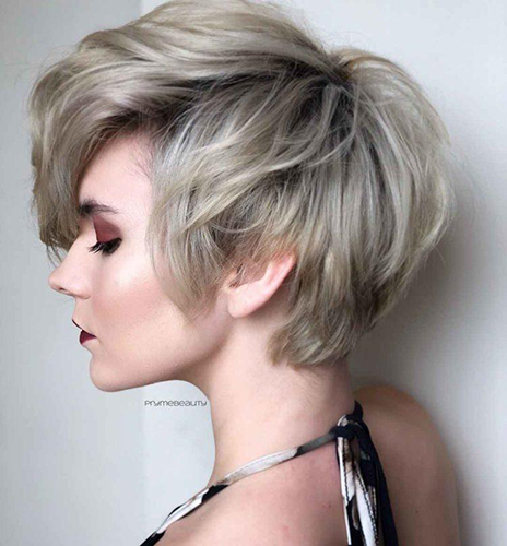 La coupe de cheveux Pixie bob pour femme est allongée, asymétrique, courte. Une photo