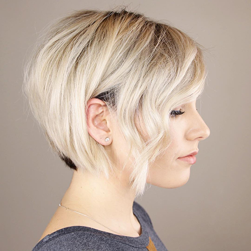 La coupe de cheveux Pixie bob pour femme est allongée, asymétrique, courte. Une photo