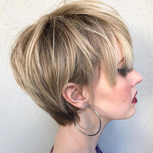 La coupe de cheveux Pixie bob pour femme est allongée, asymétrique, courte. Une photo